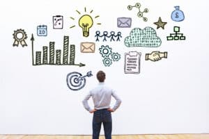 businessman looking at hand drawn business concept sketch (go-to-market strategy)