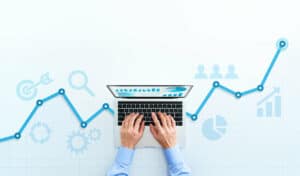 Businessman using laptop to track marketing KPIs.