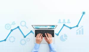 Businessman using laptop to track marketing KPIs.