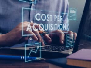 the words "cost per acquisition" overlayed on an image of a man typing on a laptop
