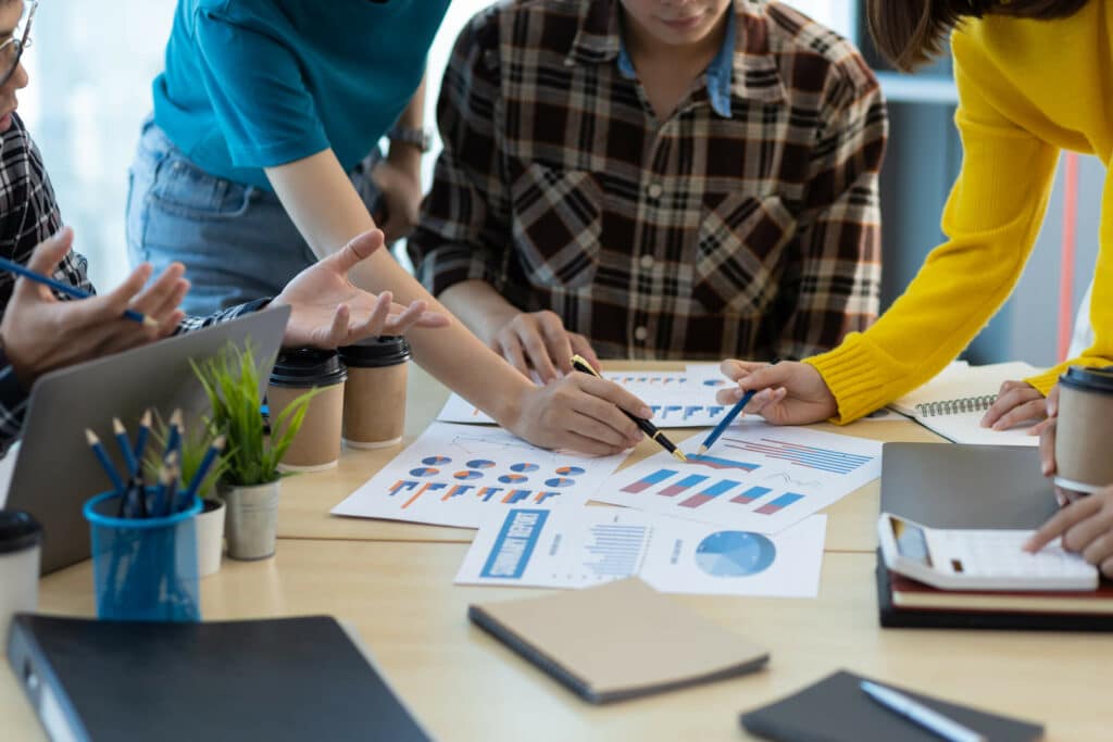 marketers looking over cost per acquisition analytics on a table