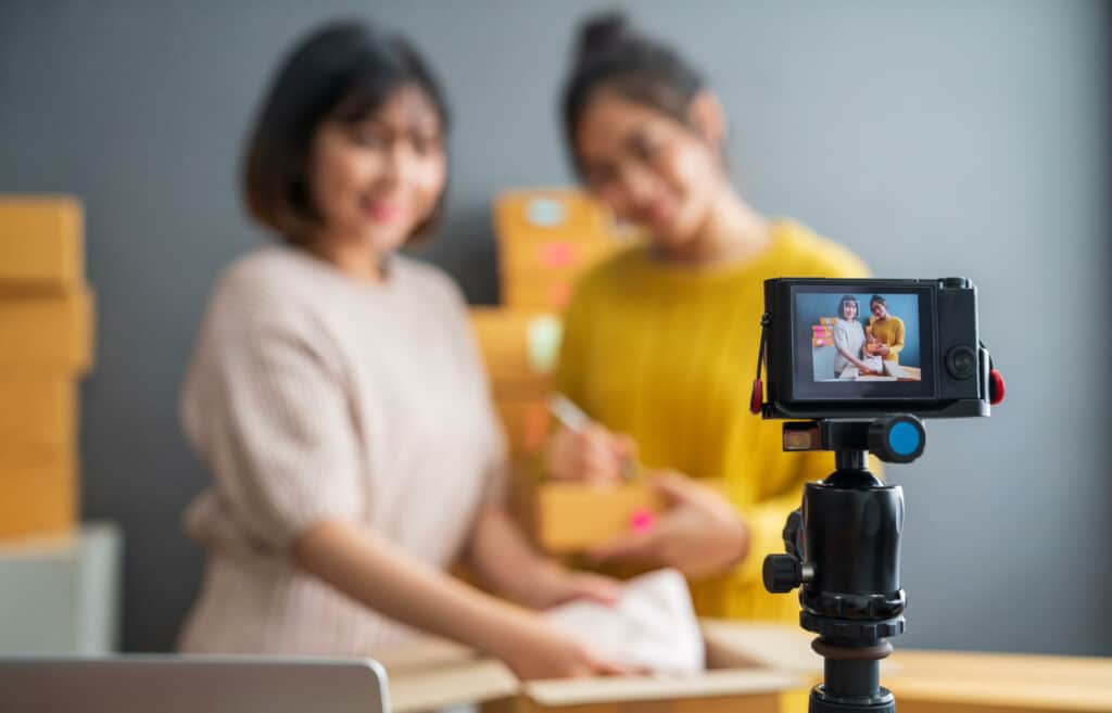 two women filming a video advertising a product (enhance offer value)