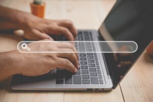 Person typing on a laptop (Best keyword research tools)