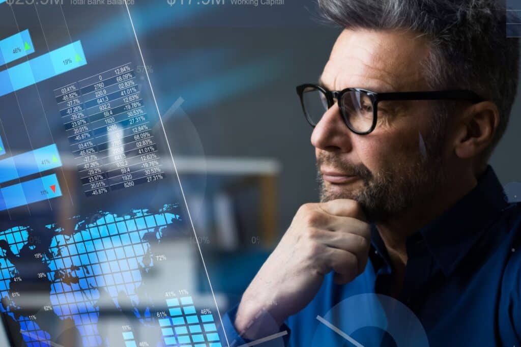 Man in glasses looking at analytics data on a screen
