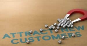 Magnet on a table that shows the words "Attract new customers" (customer acquisition cost)