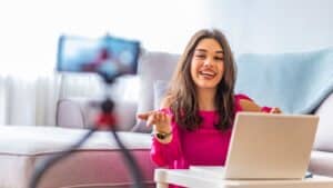 Woman in pink filming herself creating user generated content from home