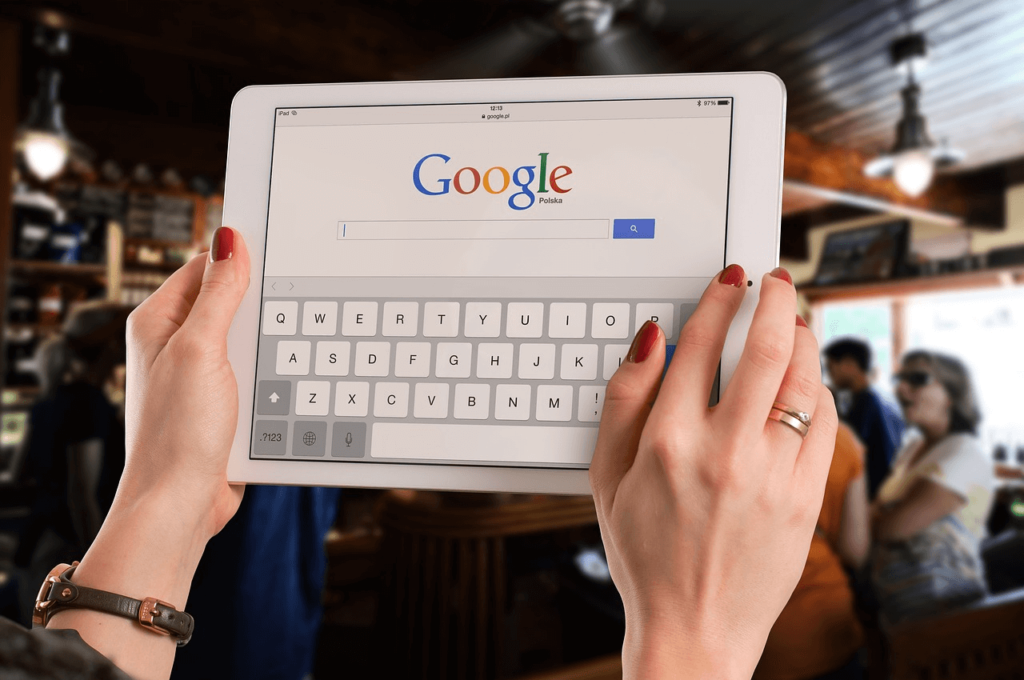 Hands holding up a white tablet with the Google search console open (local PPC ads)