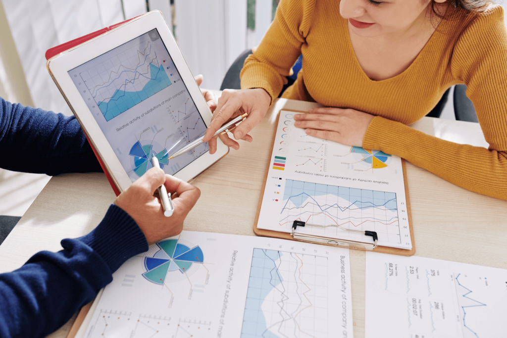 Marketers at a desk with a tablet discussing PPC competitor analysis