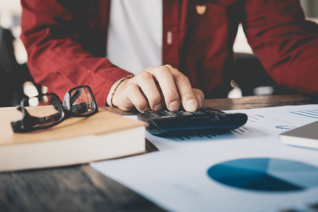Person in a red jacket using a calculator