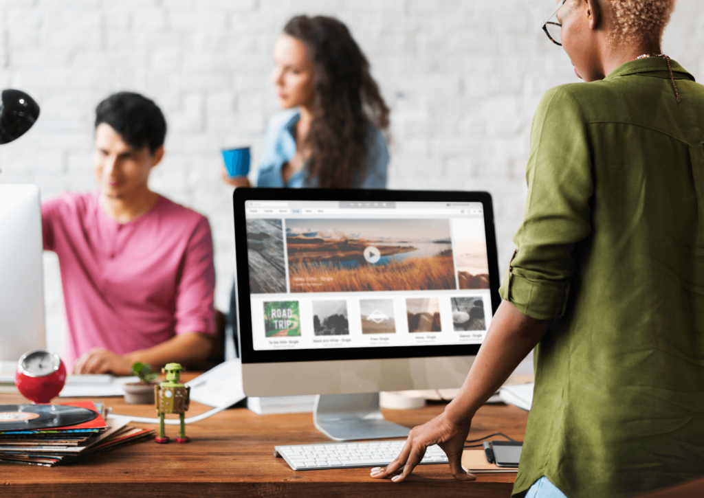 Three marketers with monitors discussing updating their website