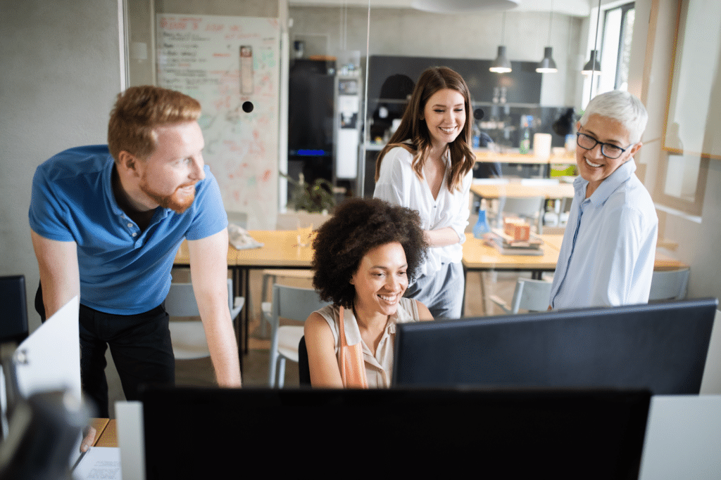 Four marketers at a table with a large monitor