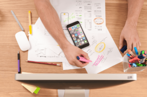 Overhead view of a person with a highlighter and several sheets of paper (website content plan)
