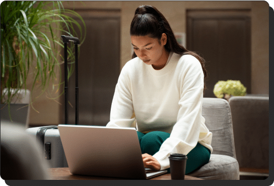 Woman at a table with a laptop (website maintenance services)
