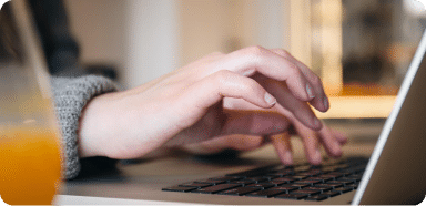Hands typing on a laptop