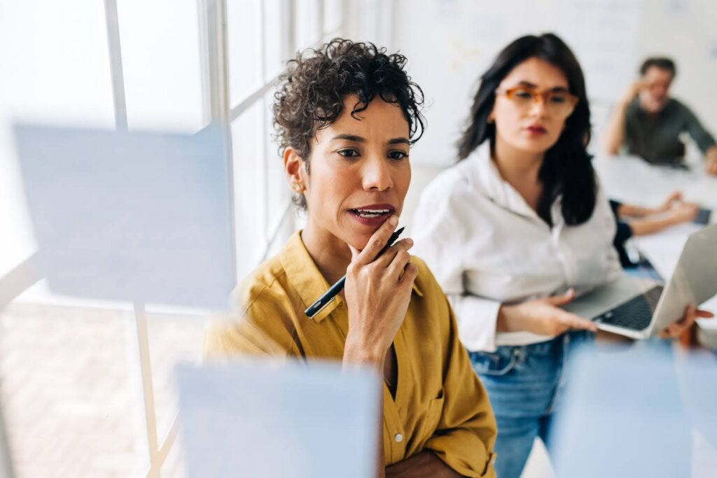 Three office workers contemplating what does a marketing consultant do