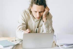 Man frustrated in front of laptop thinking how to re engage lost customers
