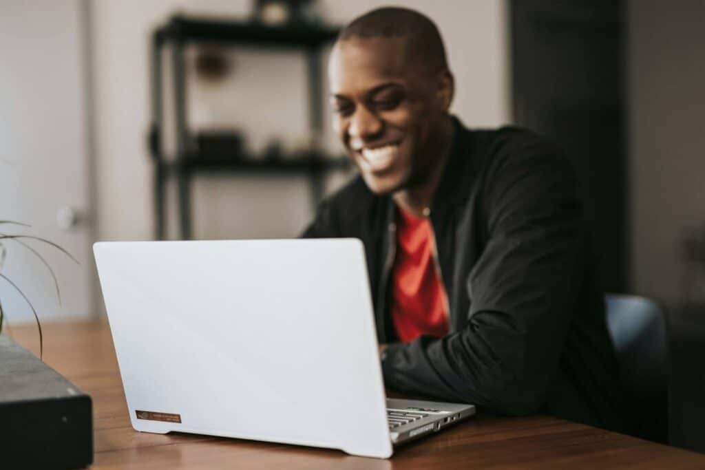Man happy on laptop after winning back lost customers