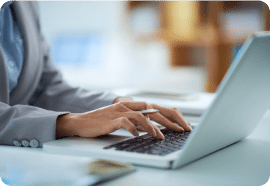 Hands typing on a laptop