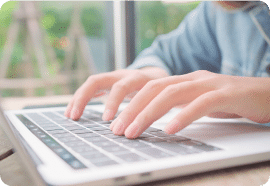 Hands typing on a laptop